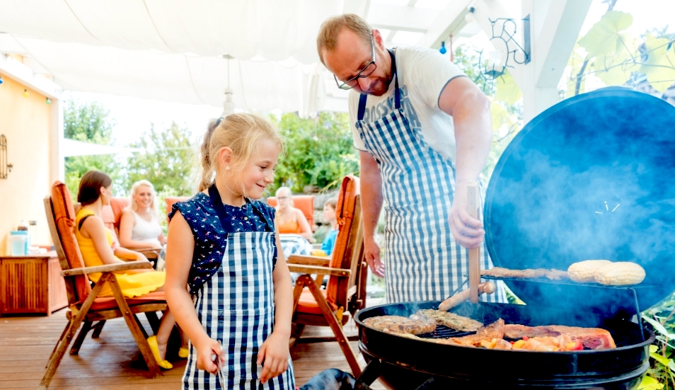 Girl and father barbecuing