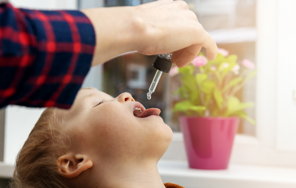 Kid taking vitamin drop